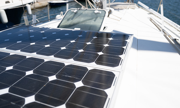 Solar panels installed on a yacht's deck with water and other boats in the background.