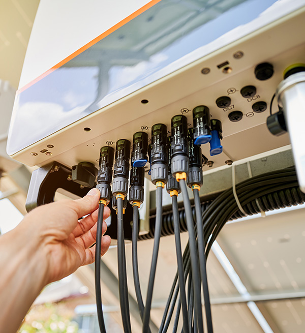 Hand adjusting marine electrical connections and wiring on a yacht installation.
